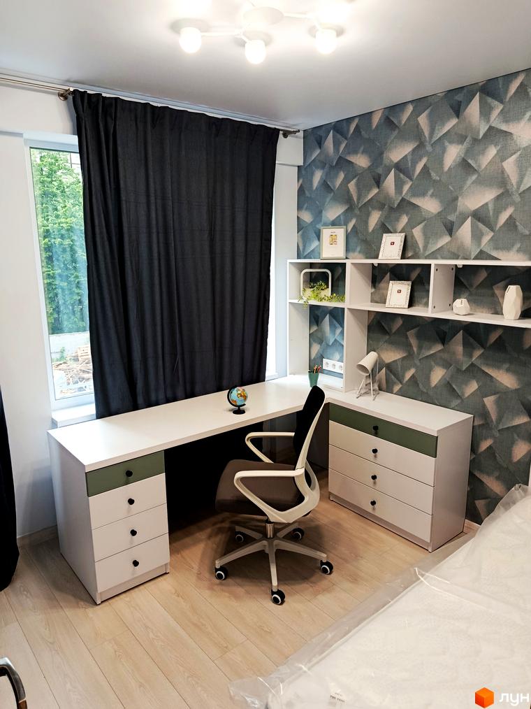 Сучасний інтер'єр квартири з робочим столом, кріслом та полицями. Дизайн кімнати з геометричними візерунками на стінах та великим вікном.