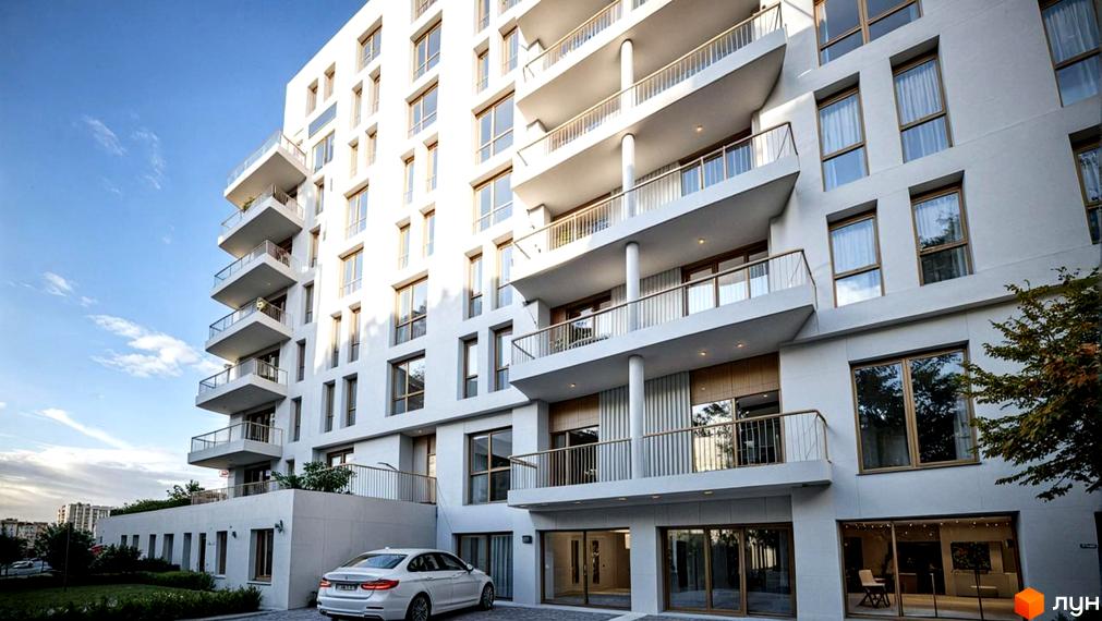 Житловий комплекс SAB Трускавець: білий багатоповерховий будинок з балконами та великими вікнами, поруч зелений газон та автомобіль.