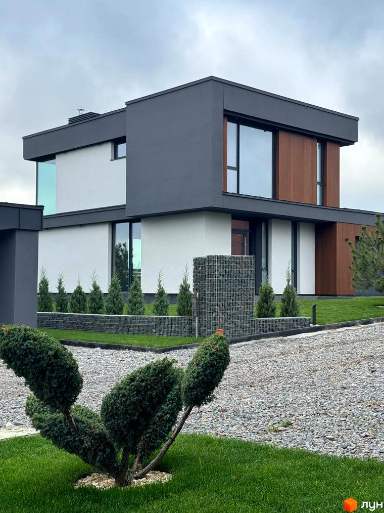 Зовнішній вигляд будинку в Котеджному містечку Prime Hill. Навколо будинку висаджені декоративні дерева та кущі.