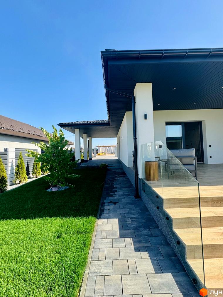 Вигляд будинку в Котеджному містечку Bratske Home з доглянутим газоном та брукованою доріжкою. Гарний краєвид новобудови.