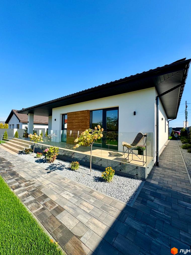 Вигляд Котеджного комплексу Bratske Home з прибудинковою територією. На подвір'ї розташовані декоративні рослини та зручна доріжка.