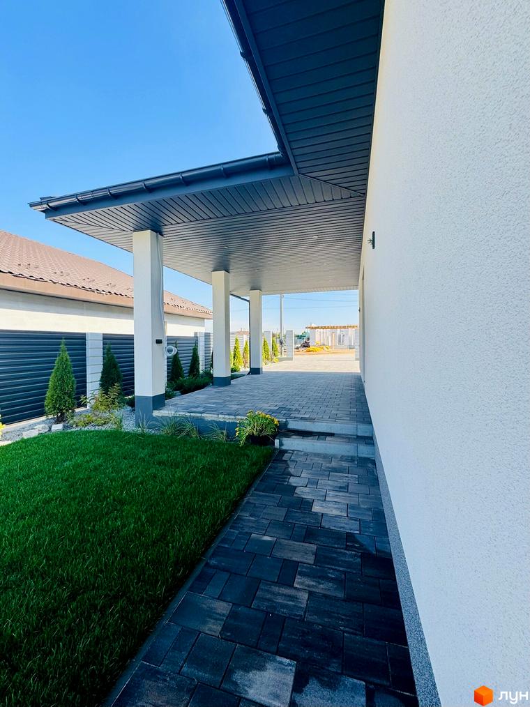 Зображення будинку в Котеджному містечку Bratske Home. Вигляд фасаду та прибудинкової території з газоном і тротуарною плиткою.