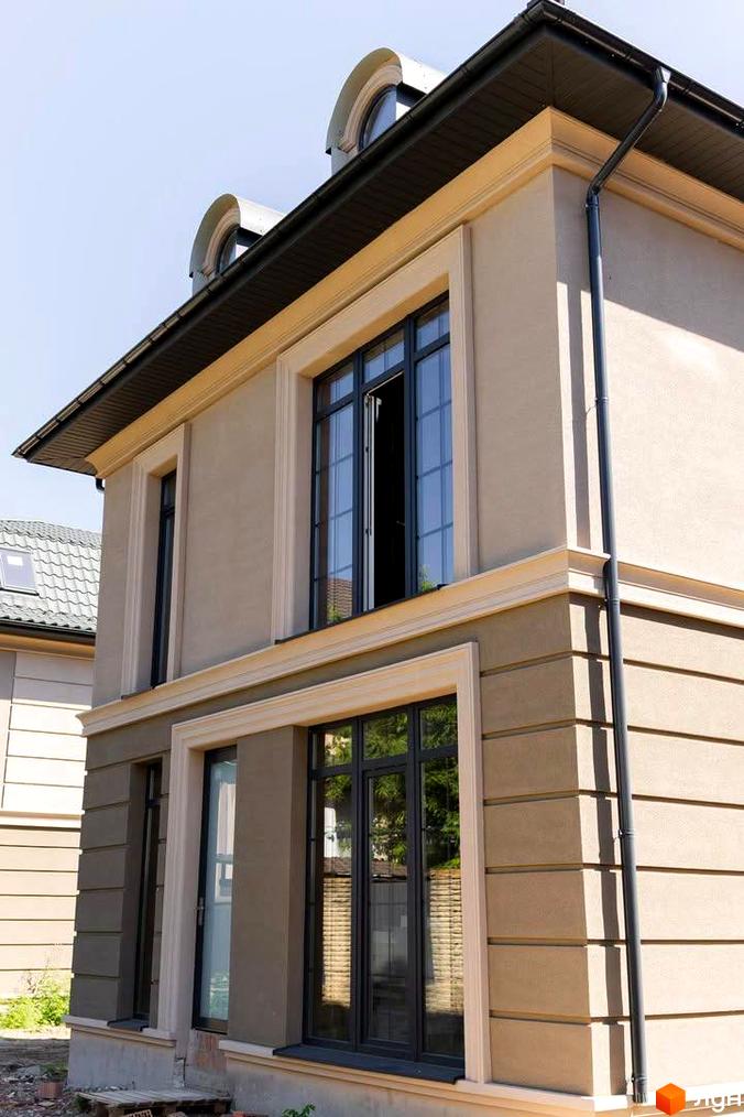 Зовнішній вигляд двоповерхового будинку в Котеджному містечку 5 element з великими вікнами та оздобленням фасаду. Вигляд з вулиці в сонячний день.