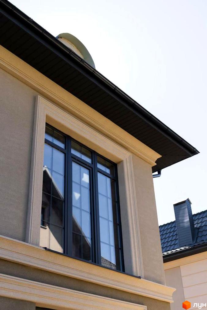 Зовнішній вигляд будинку в Котеджному містечку 5 element з великими вікнами та оздобленням фасаду. На задньому плані видно дах сусіднього будинку.