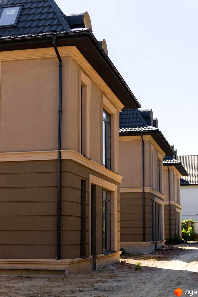 Зовнішній вигляд таунхаусів у Котеджному містечку 5 element. Двоповерхові будинки з коричневим оздобленням та темним дахом.