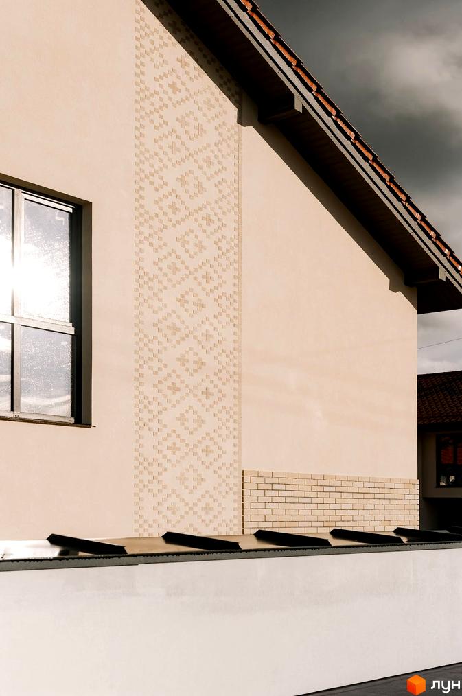 Зовнішній вигляд будинку в Котеджному містечку Етнія з вікном та декоративною кладкою. Видно частину даху та стіни сусіднього будинку.