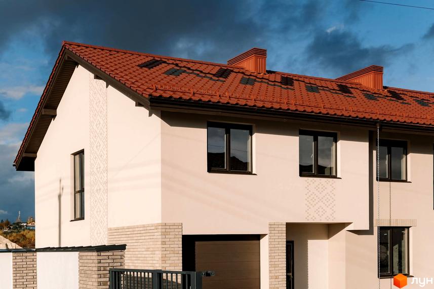 Зовнішній вигляд будинку в Котеджному містечку Етнія з червоною черепицею на даху. Вигляд на фасад та прибудинкову територію.