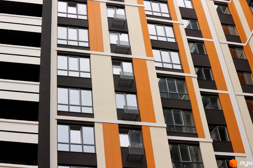 Зовнішній вигляд фасаду Новобудови Фаворит Premium з великими вікнами та балконами. Архітектура з використанням коричневих та бежевих кольорів.