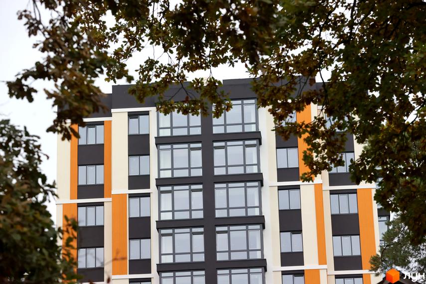 Зовнішній вигляд фасаду Житлового комплексу Favorit Premium з великими вікнами та оздобленням у чорно-жовтих кольорах.