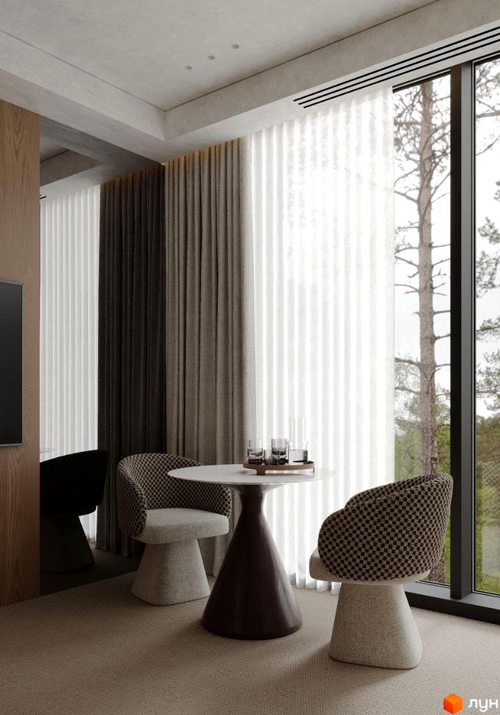 Інтер'єр кімнати в Crystal Hills: круглий стіл, крісла з візерунком, великі вікна з видом на природу. Затишний куточок для відпочинку.