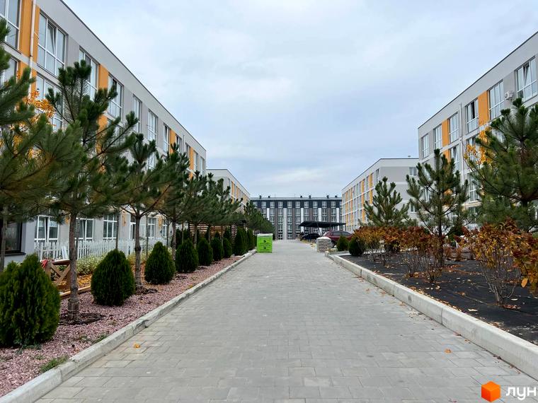 Вигляд на фасади будинків Житлового комплексу Sanville Park та пішохідну алею з озелененням. Двори з ландшафтним дизайном.