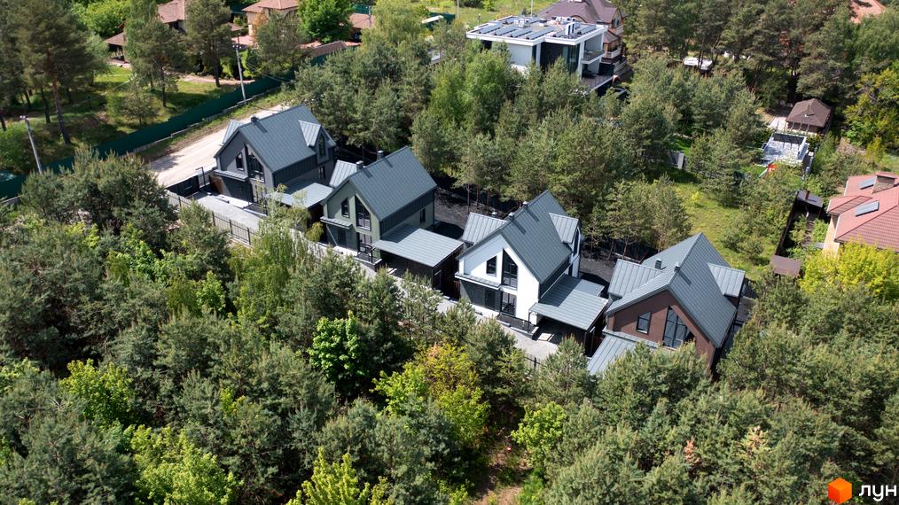 Вигляд зверху на Котеджне містечко Strilets'sky з будинками з сірими дахами, що розташовані серед зелених дерев.