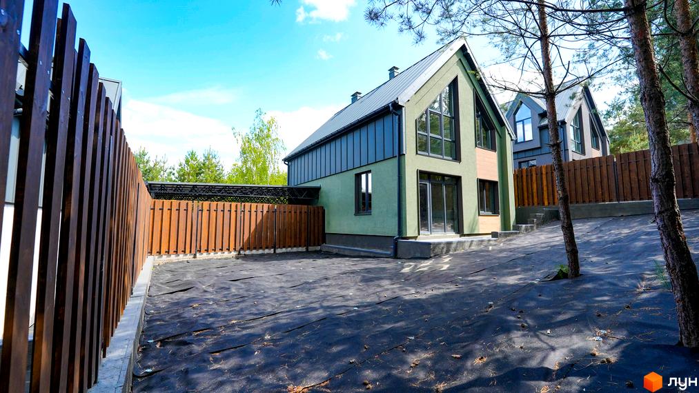 Зображення будинку в Котеджному містечку Strilets'sky з великими вікнами та двоповерховою конструкцією. Навколо будинку облаштована територія.