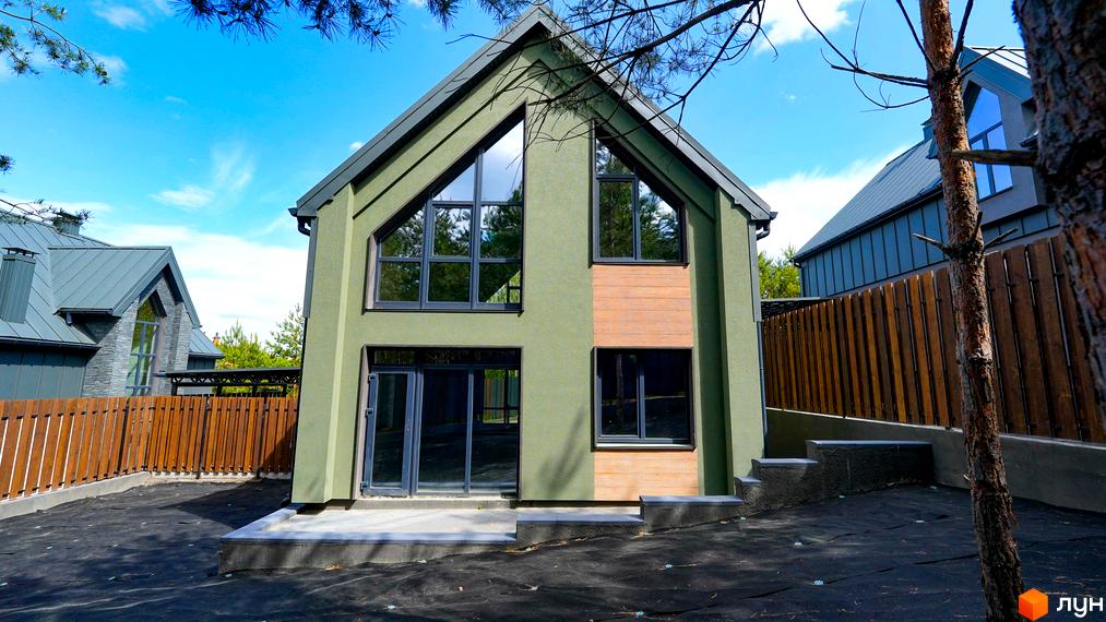 Зовнішній вигляд будинку в Котеджному містечку Strilets'sky з великими вікнами та прибудинковою територією.