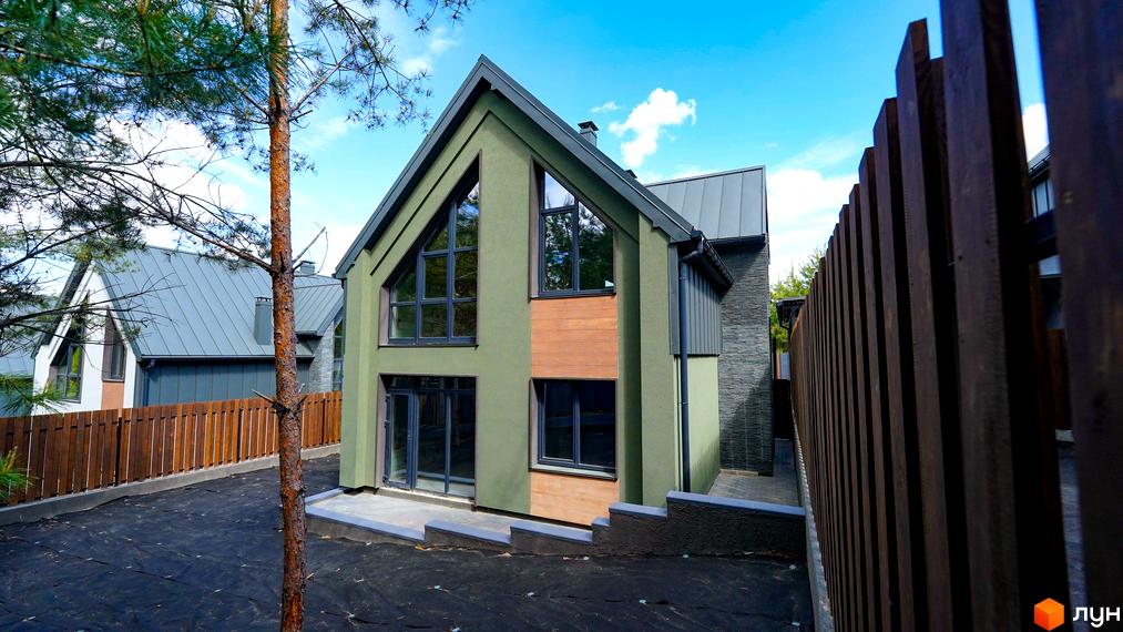 Зображення будинку в Котеджному містечку Strilets'sky з великими вікнами та дерев'яним оздобленням. Навколо будинку облаштована територія.