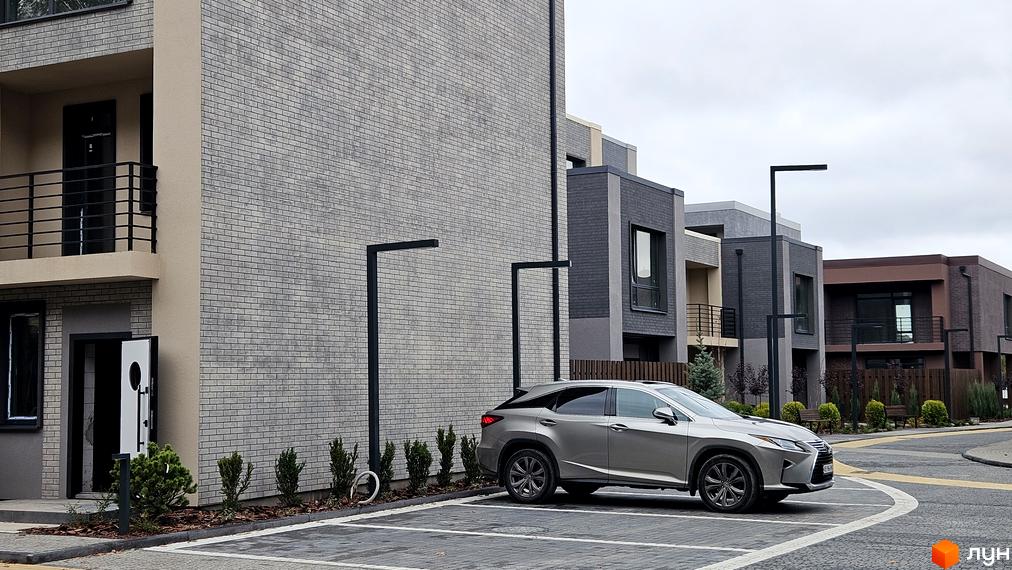 Зображення таунхаусів Житлового комплексу Sвій Dім 2. На фото будинок з сірої цегли та припаркований автомобіль.