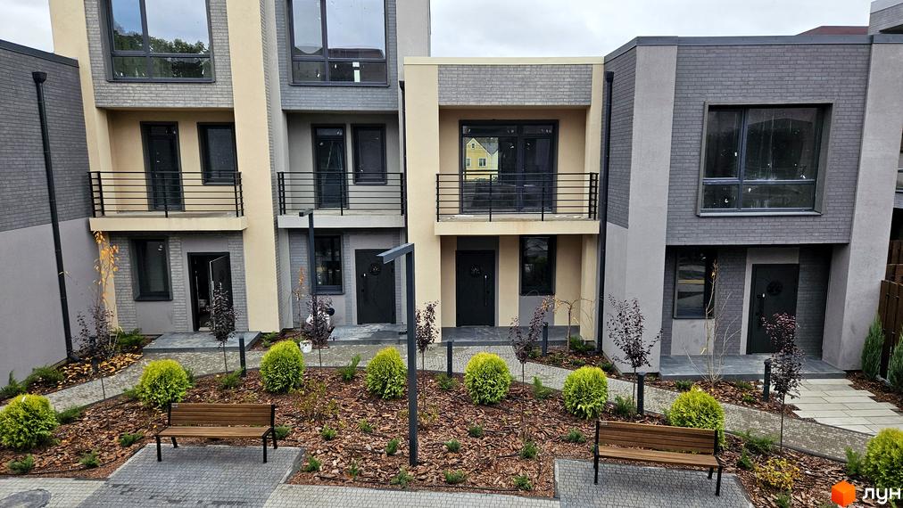 Зображення таунхаусів Sвій Dім 2. На фото три двоповерхові будинки з балконами, перед якими розташовані лавки та зелені насадження.