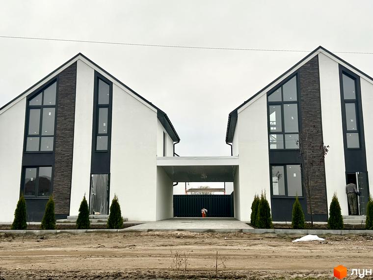 Зовнішній вигляд будинків у Котеджному містечку DESNA HOMES з великими вікнами та озелененням на прибудинковій території.
