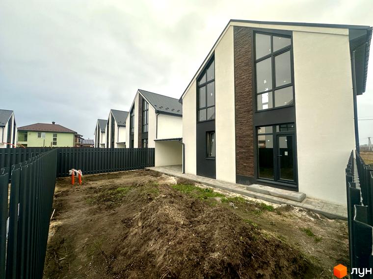 Зовнішній вигляд будинку в Котеджному містечку DESNA HOMES. Прибудинкова територія з чорним парканом та землею.