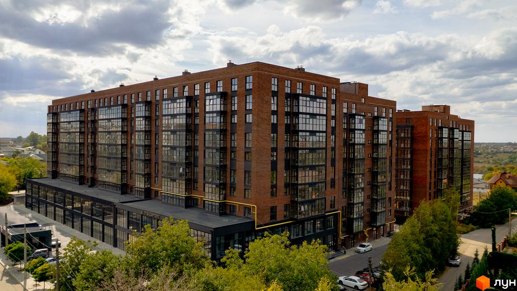 Зображення фасаду та прибудинкової території Житлового комплексу Стандарт. Вигляд з висоти на цегляну багатоповерхівку.