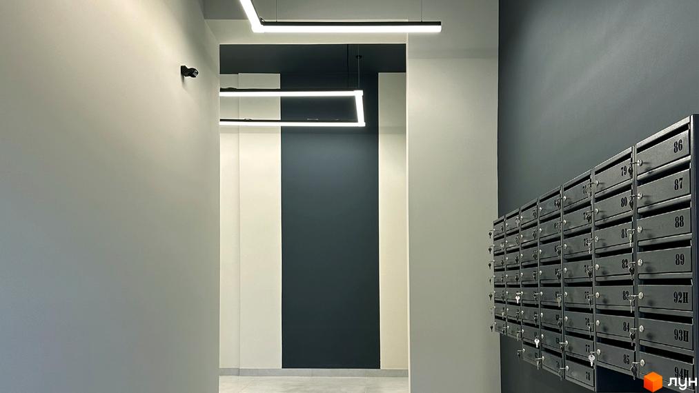 Інтер'єр холу Житлового комплексу Стандарт з поштовими скриньками та сучасним освітленням. Вигляд вхідної зони з елементами дизайну.