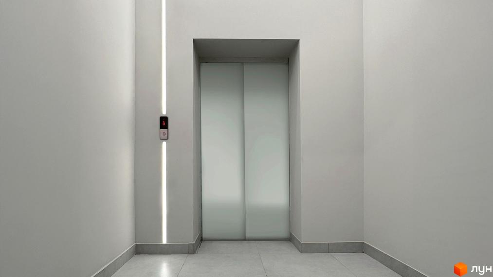 Фото ліфту в Новобудові Стандарт. Світлий інтер'єр з підсвічуванням та кнопками виклику ліфта.