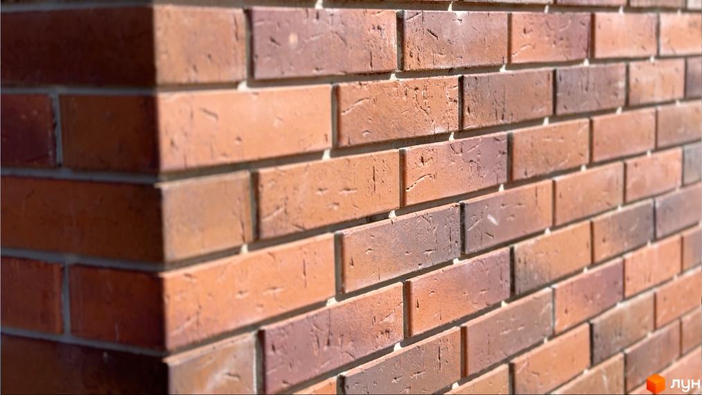 Фасад будинку з червоної цегли у Житловому комплексі Стандарт. Цегляна кладка створює надійний та естетичний вигляд будівлі.