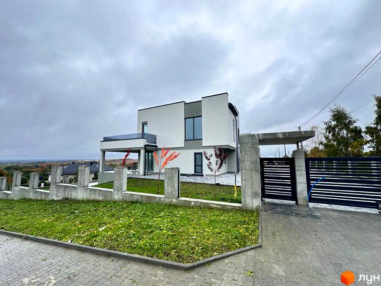 Зовнішній вигляд будинку в Котеджному містечку Belvedere з прибудинковою територією та зеленим газоном.