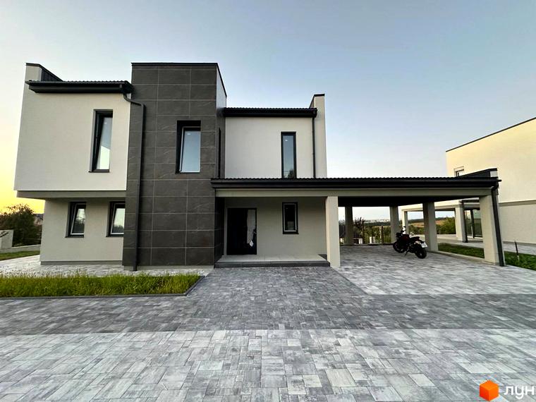 Зовнішній вигляд двоповерхового будинку в Котеджному містечку Belvedere. На передньому плані сіра бруківка та зелений газон.