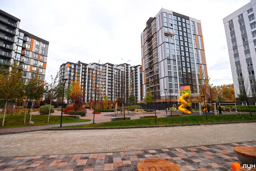 Високі будинки ЖК Атмосфера з панорамними вікнами та яскравими вставками на фасаді. На території облаштований дитячий майданчик та зони відпочинку.