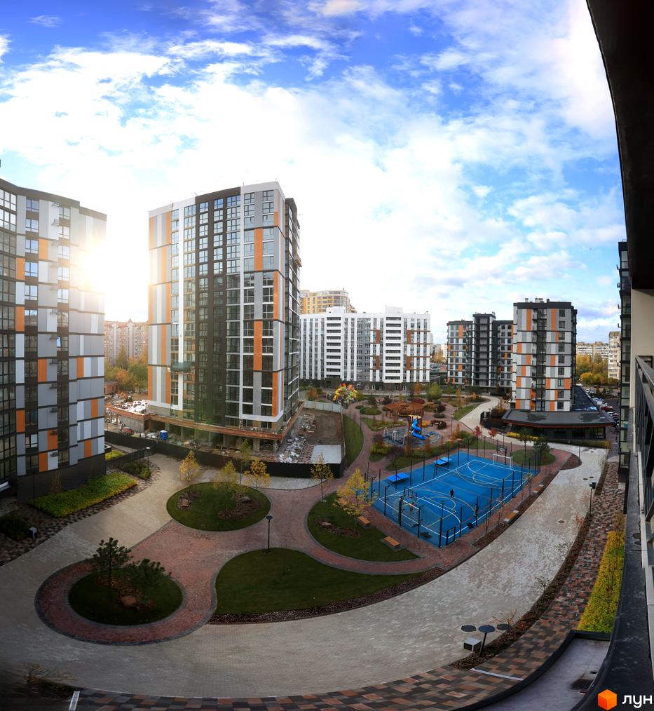 Високоповерховий будинок ЖК Атмосфера з панорамними вікнами, дитячим майданчиком та спортивним майданчиком на території. Благоустрій прибудинкової території.
