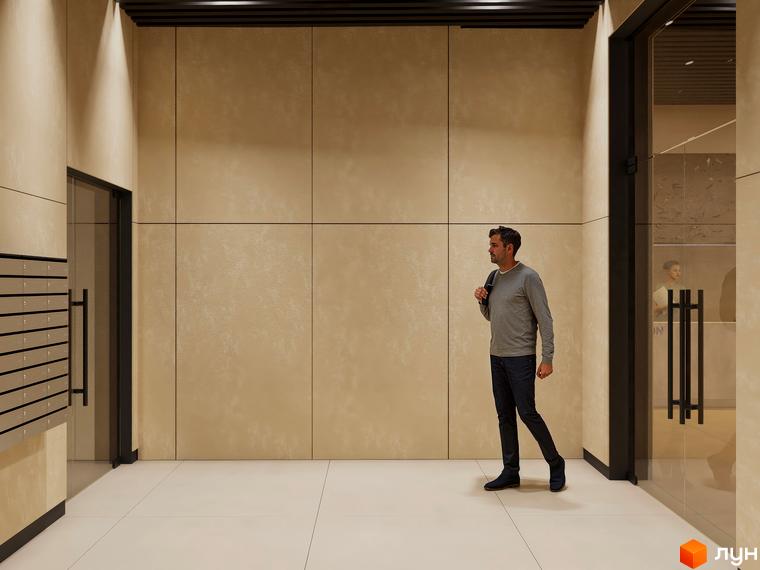 Чоловік заходить у хол житлового комплексу Emily Apartments. Стіни оздоблені світлими панелями, підлога викладена плиткою.