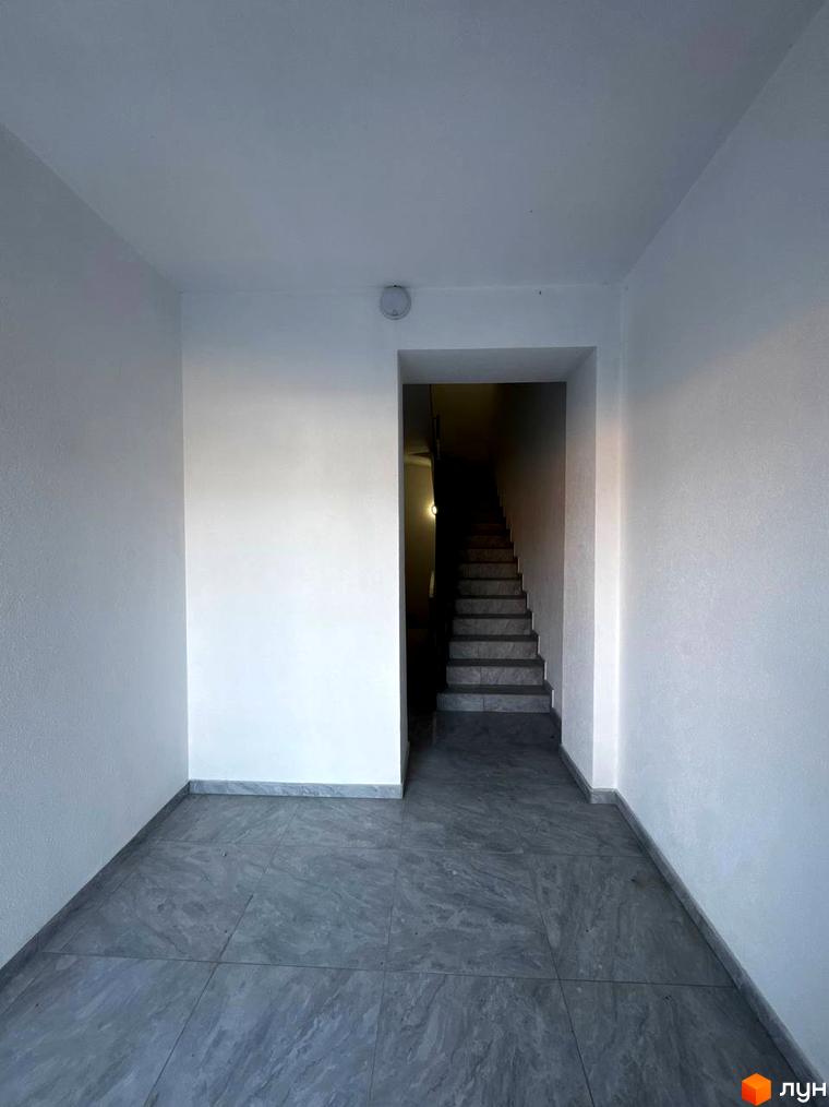 Вхідна група до житлового комплексу Затишок з сірою плиткою на підлозі та сходами. Зовнішній вигляд новобудови.