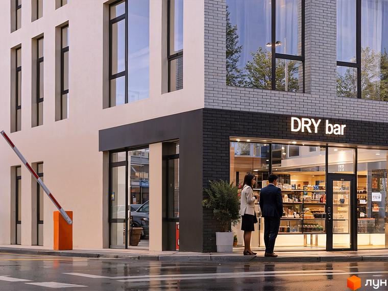 Зовнішній вигляд БФК Shevchenka 58a з цегляним фасадом та вікнами, на передньому плані виїзна брама та мокра дорога.