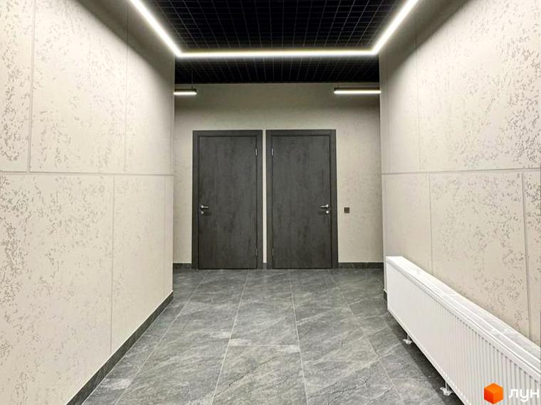 Коридор у житловому комплексі Standard LUX з двома дверима та підлогою під мармур. Сучасне освітлення та оздоблення стін.