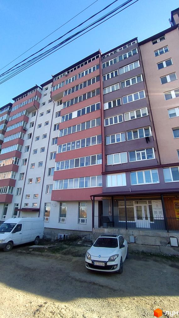 Зовнішній вигляд багатоквартирного будинку на вул. Головна, 275ж, 275е, з прибудинковою територією та автомобілями.