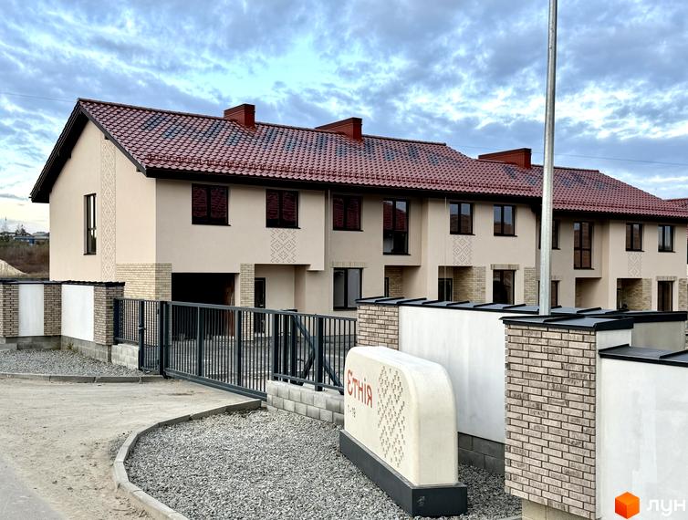 Котеджне містечко Етнія: фасади будинків з червоною черепицею та цегляними елементами, огороджена територія з брамою.