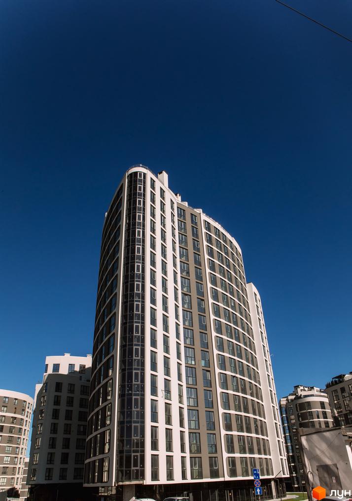 Житловий комплекс Парус City – висотні будинки з вигнутими фасадами та панорамним склінням на тлі блакитного неба.