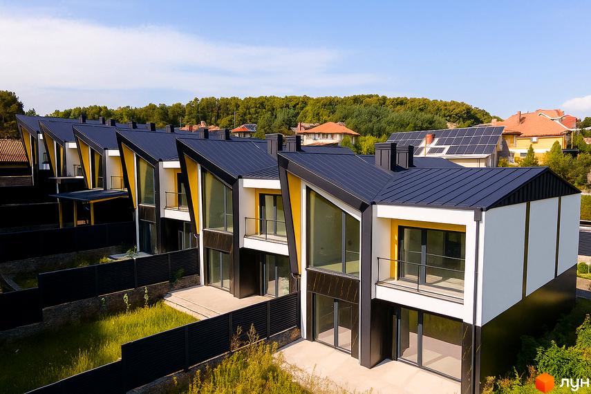 Таунхаус ДЖЕРЕЛЬНА: сучасні будинки з чорними дахами та жовтими акцентами, огороджена територія з газоном. Комплекс розташований на схилі пагорба.