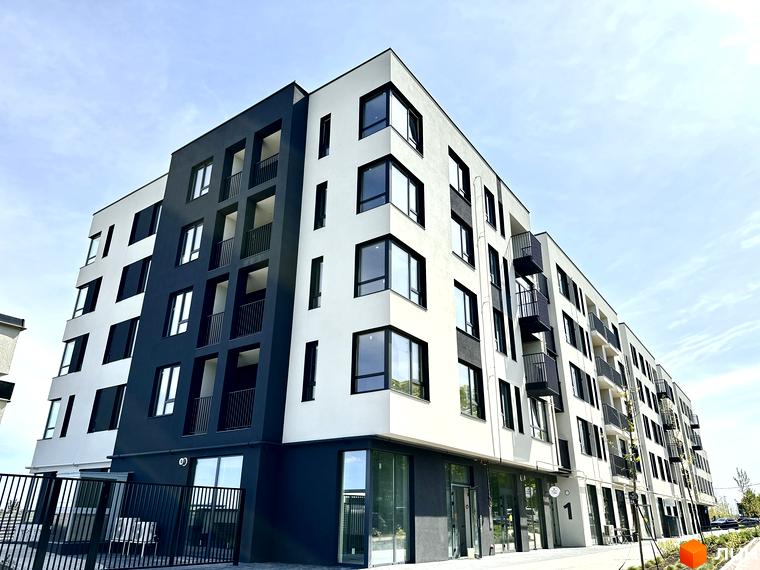 Новобудова ЖК Empatika з біло-темно-синім фасадом та балконами. Поруч розташована огорожа та тротуар.