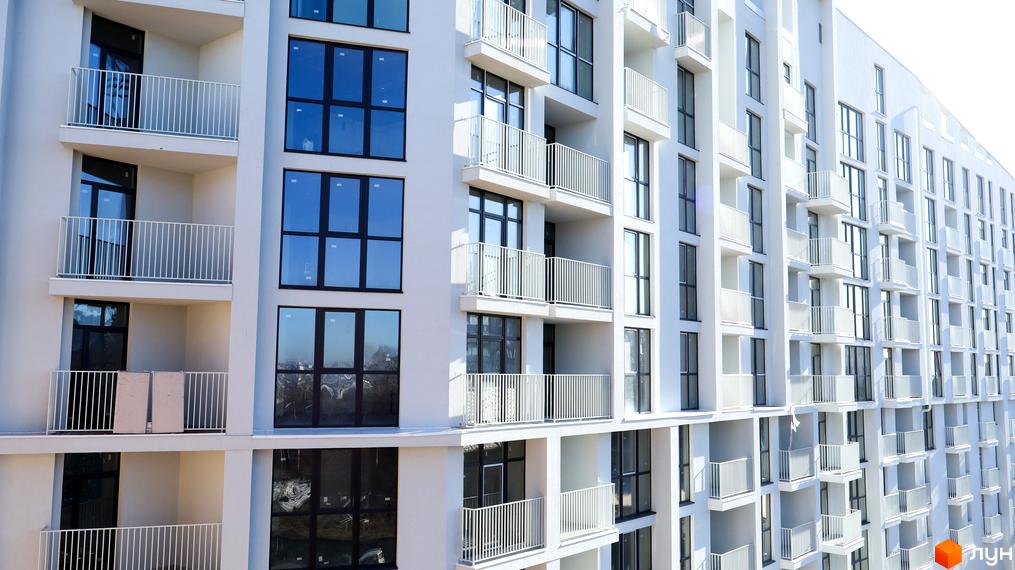 Фасад житлового комплексу Pokrovsky Apart Complex з балконами та великими вікнами. Зовнішній вигляд новобудови.