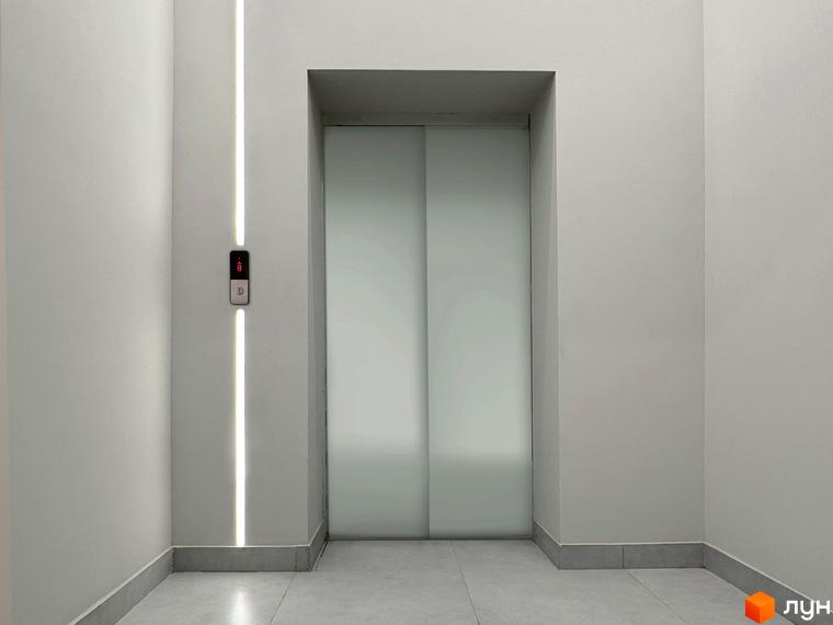 Фото ліфта в житловому комплексі Стандарт. Мінімалістичний дизайн з підсвіткою та кнопками виклику.
