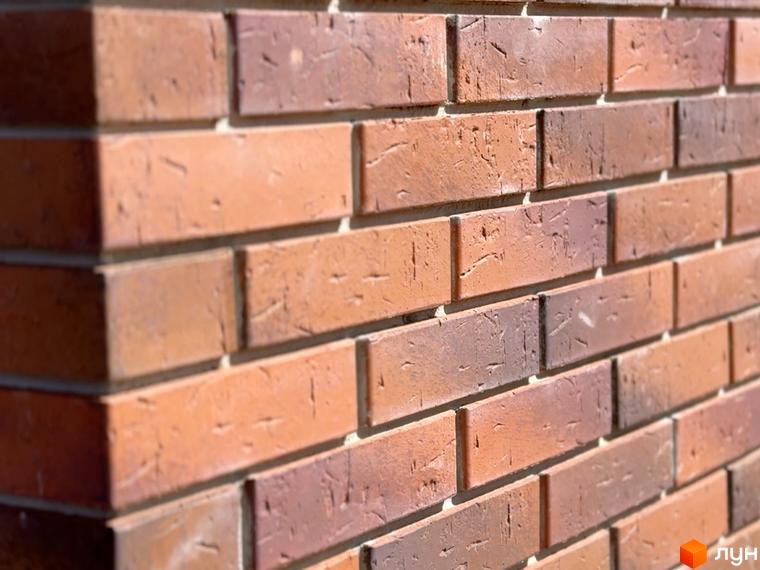 Облицювання фасаду новобудови ЖК Стандарт цегляною кладкою теракотових відтінків. Деталі фасаду та текстура цегли.