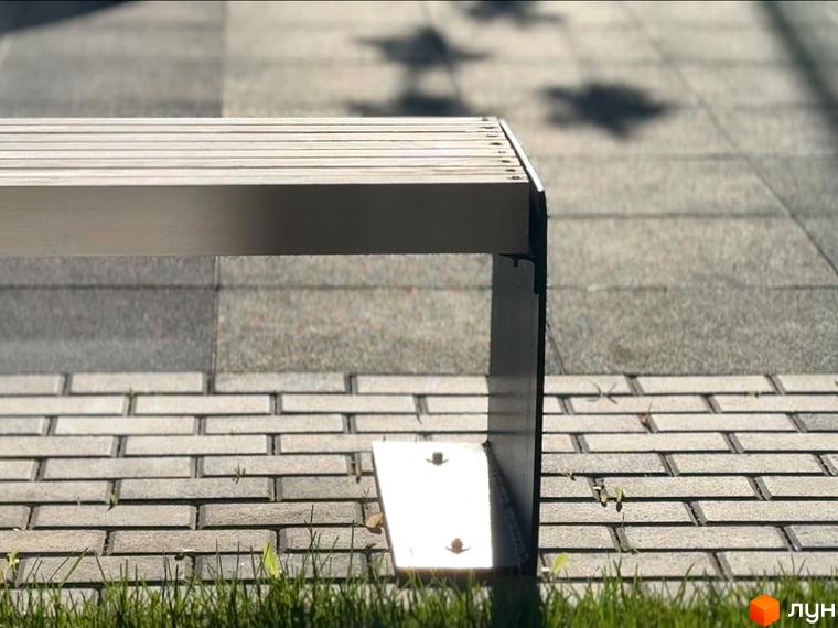 Зовнішній вигляд новобудови ЖК Стандарт з лаконічним дизайном фасаду та облаштованою прибудинковою територією з бруківки та трави.