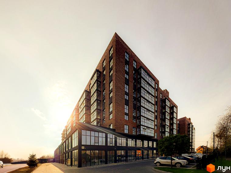 Зовнішній вигляд житлового комплексу Стандарт з цегляним фасадом та скляними балконами. Прибудинкова територія з парковкою та зеленими насадженнями.