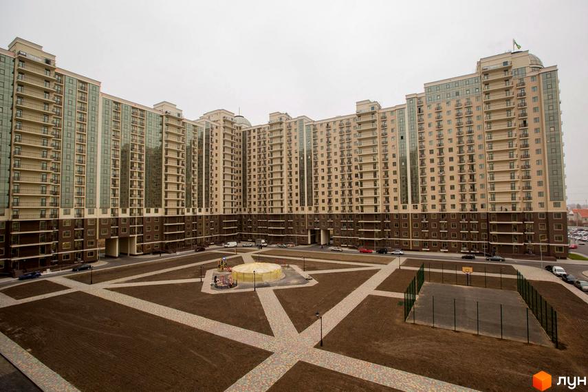 Житловий комплекс Пятая Жемчужина з сучасними фасадами та прибудинковою територією, що включає дитячий майданчик та спортивні зони.