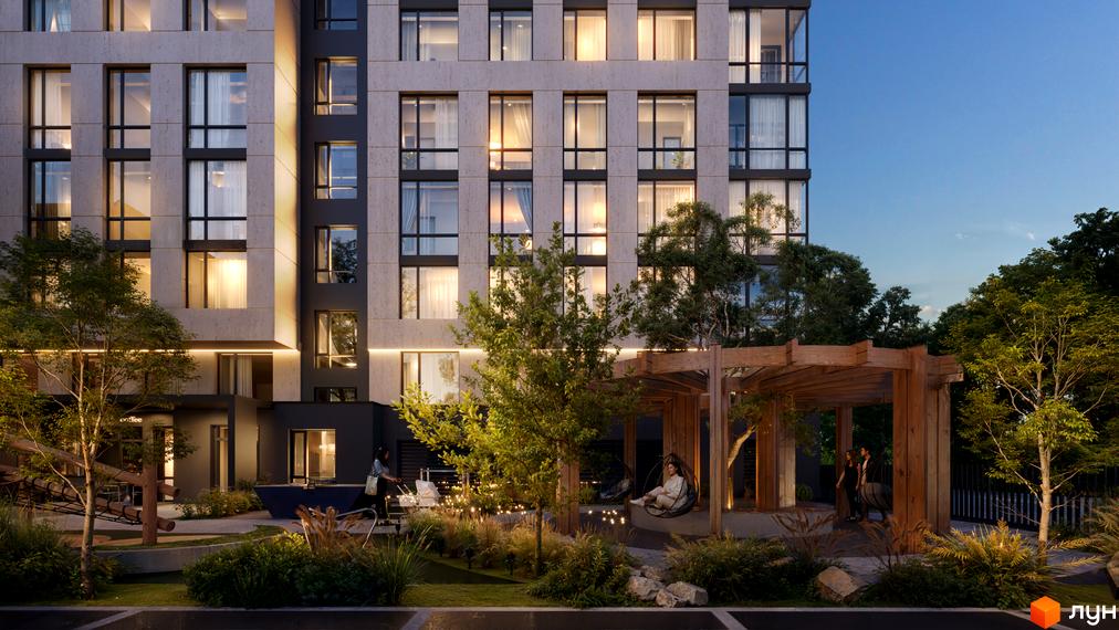 Новобудова D25 з великими вікнами та підсвіткою фасаду. На прибудинковій території розташовані зони відпочинку з навісом та зелені насадження.