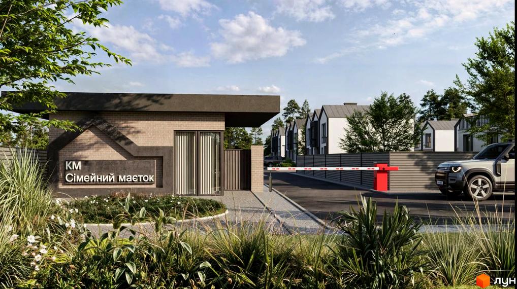 Котеджне містечко Сімейний маєток: в'їзд на територію з шлагбаумом і сучасними таунхаусами на задньому плані. Зелена прибудинкова територія з доглянутими рослинами.