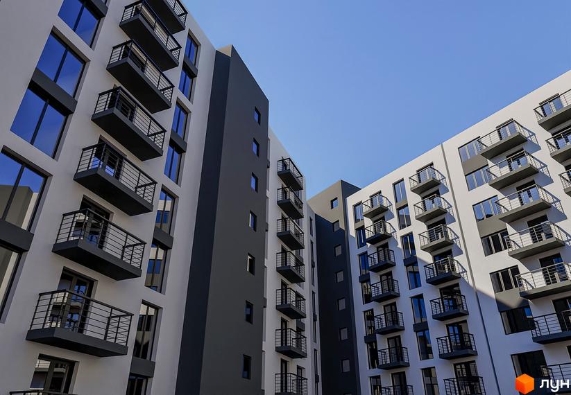 Зовнішній вигляд новобудови ЖК Урожайний: білі та сірі фасади з балконами та темними вікнами на тлі блакитного неба.