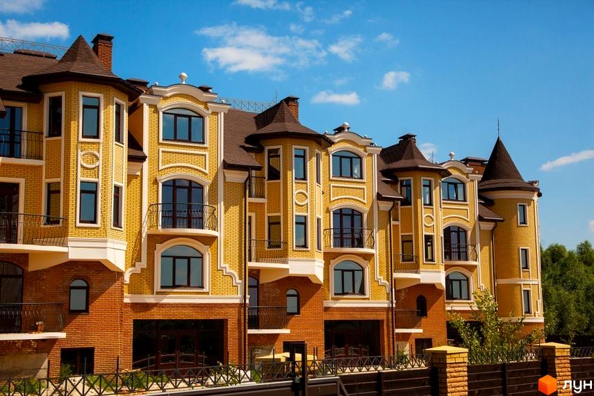 Елегантний будинок з жовтої цегли з темною покрівлею. Котеджне містечко Хутір Ясний з красивою прибудинковою територією.